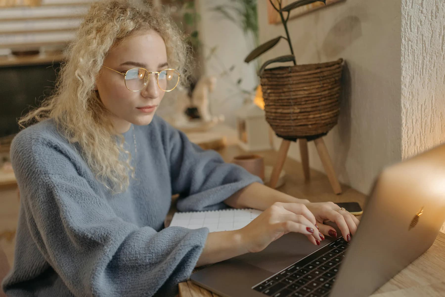 Person fordypet i laptop på et koselig hjemmekontor — å ta grep om gjelden og starte på nytt